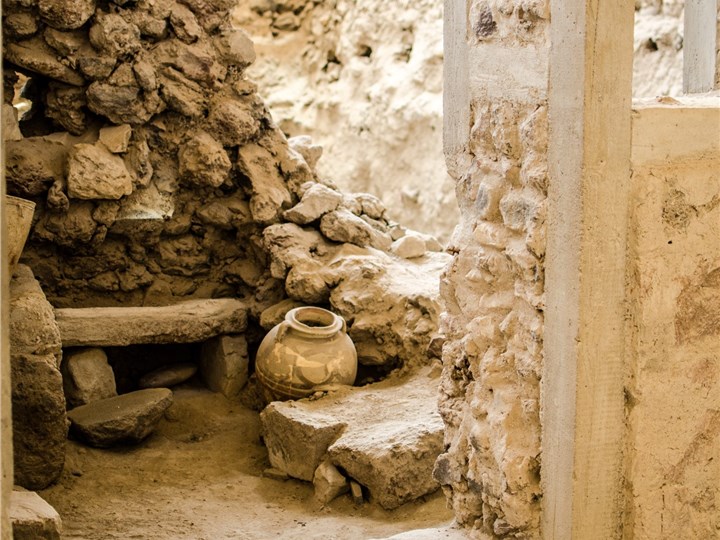 Photo site Excavations of Akrotiri, Santorini.
A stone wall with a pot and bench 